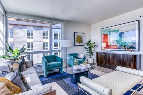 Cozy living room with modern decor and large windows in Cypress Apartments, ideal for relaxation and entertainment