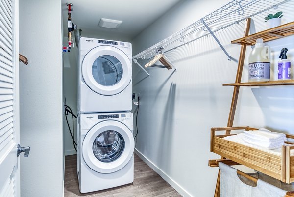 Laundry room featuring modern appliances at Cypress Apartments