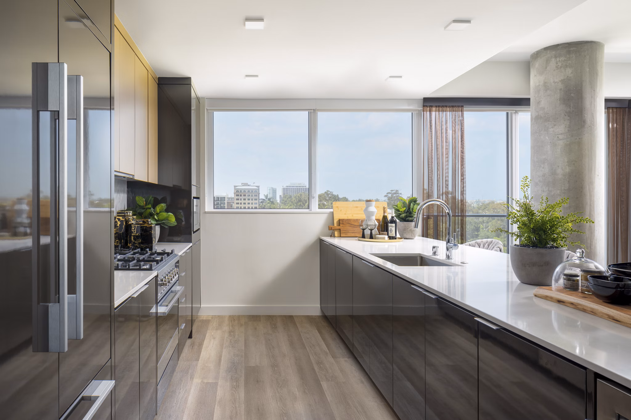 Modern kitchen with stainless steel appliances and island counter at 525 Olive Apartments, luxury living in the heart of the city