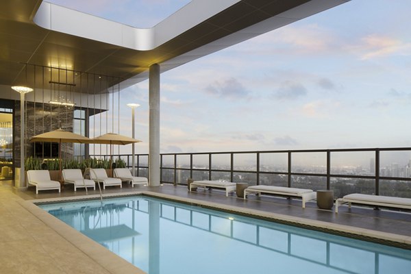Poolside relaxation at 525 Olive Apartments, featuring luxury seating and skyline views