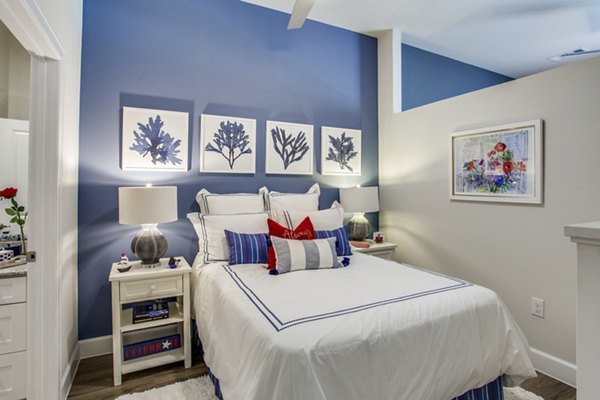 Bedroom with modern decor including a plush bed and stylish lighting in Quest Apartments, luxury living space