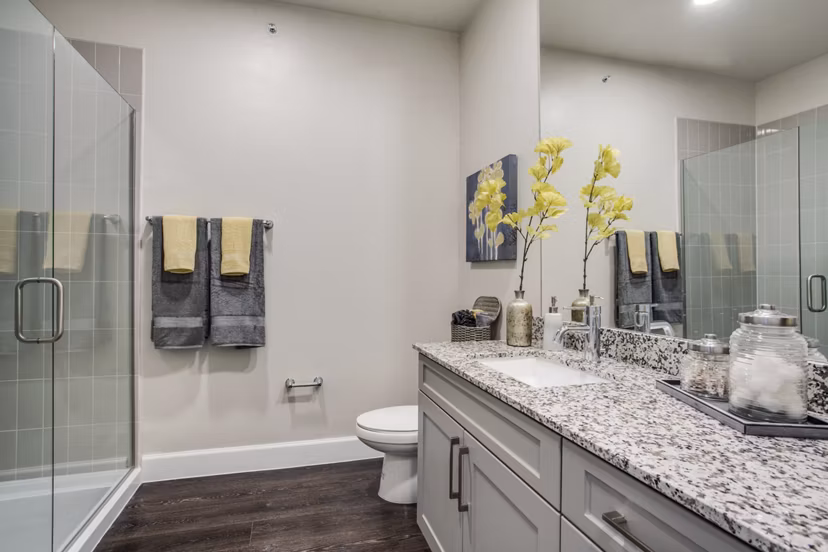 Modern bathroom featuring sleek design and large mirror at Quest Apartments