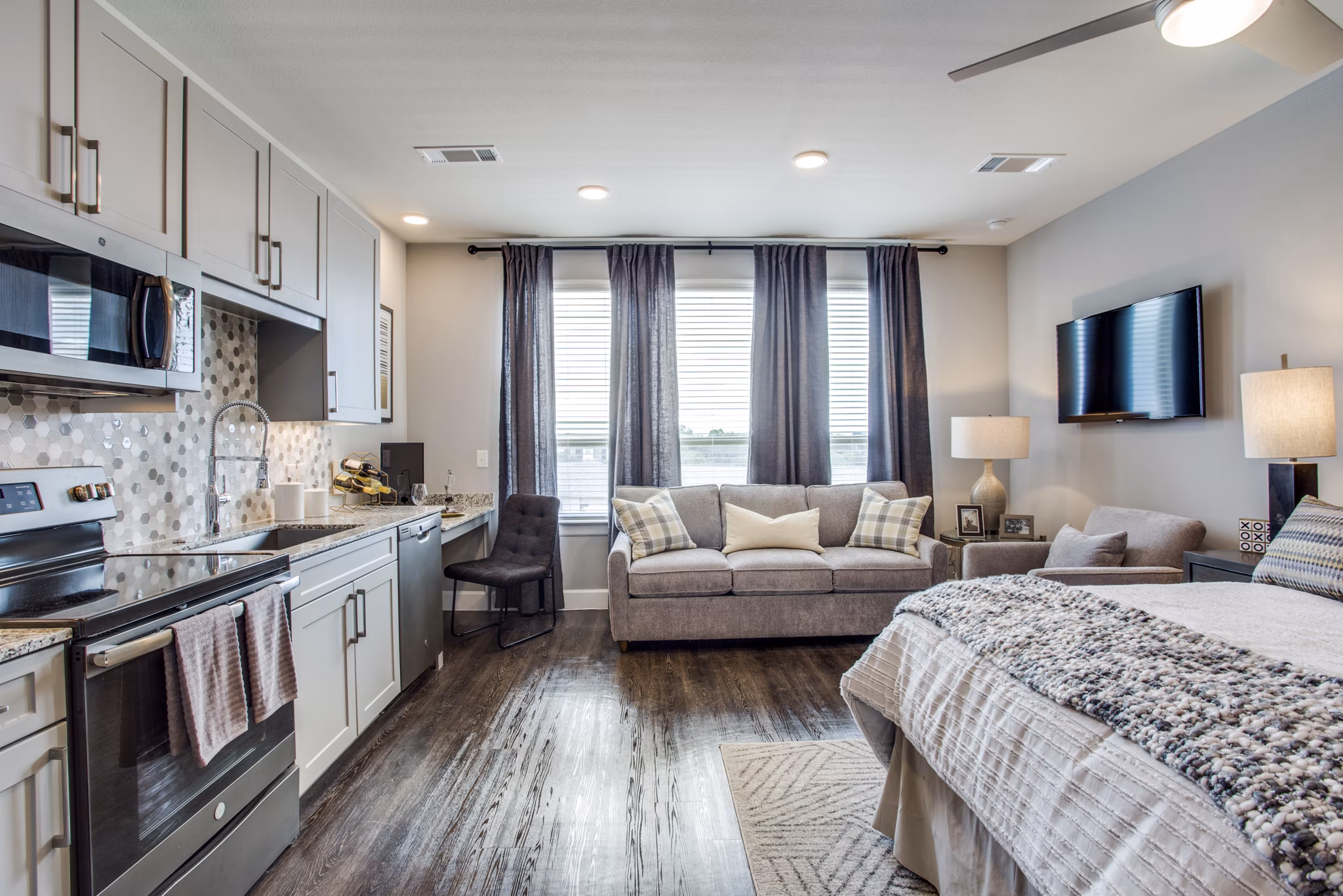 Modern kitchen with stainless steel appliances and island counter in Quest Apartments
