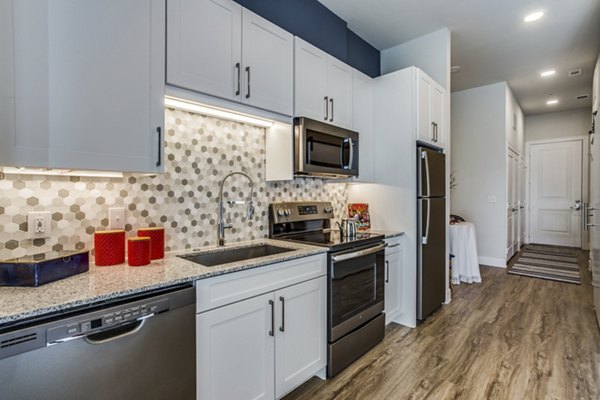 Modern kitchen with stainless steel appliances in Quest Apartments, offering luxury living experiences