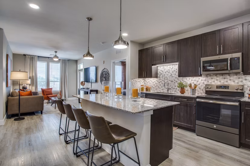 Sleek kitchen with granite countertops and stainless steel appliances at Quest Apartments