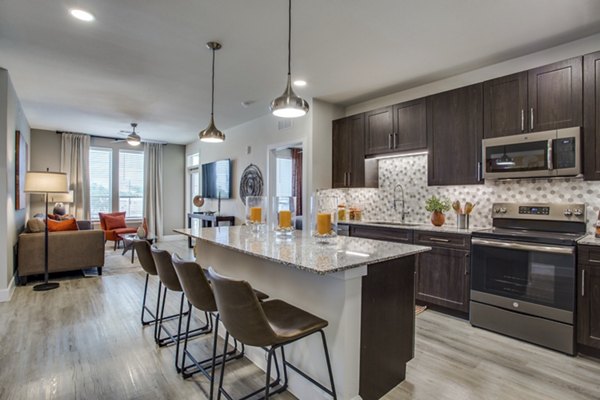 Sleek kitchen with granite countertops and stainless steel appliances at Quest Apartments