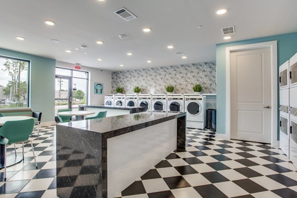 Modern laundry facility with state-of-the-art machines at Quest Apartments for resident convenience