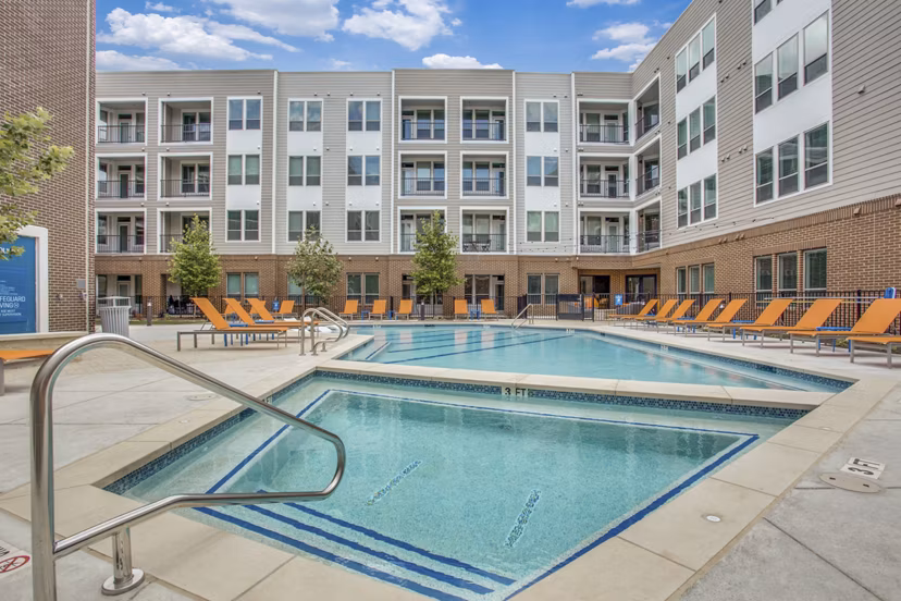 Panoramic pool views at Quest Apartments' luxury recreation area with lounge seating nearby