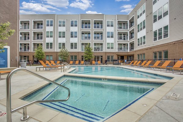 Panoramic pool views at Quest Apartments' luxury recreation area with lounge seating nearby