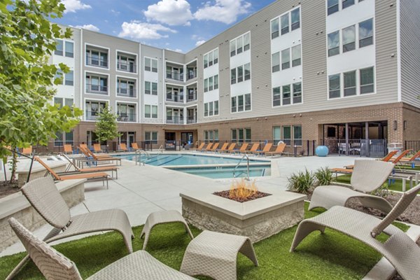 Cozy fire pit area at Quest Apartments for residents to relax and socialize outdoors in a luxurious setting