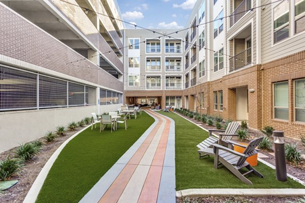 Courtyard featuring lush landscaping and lounging areas at Quest Apartments