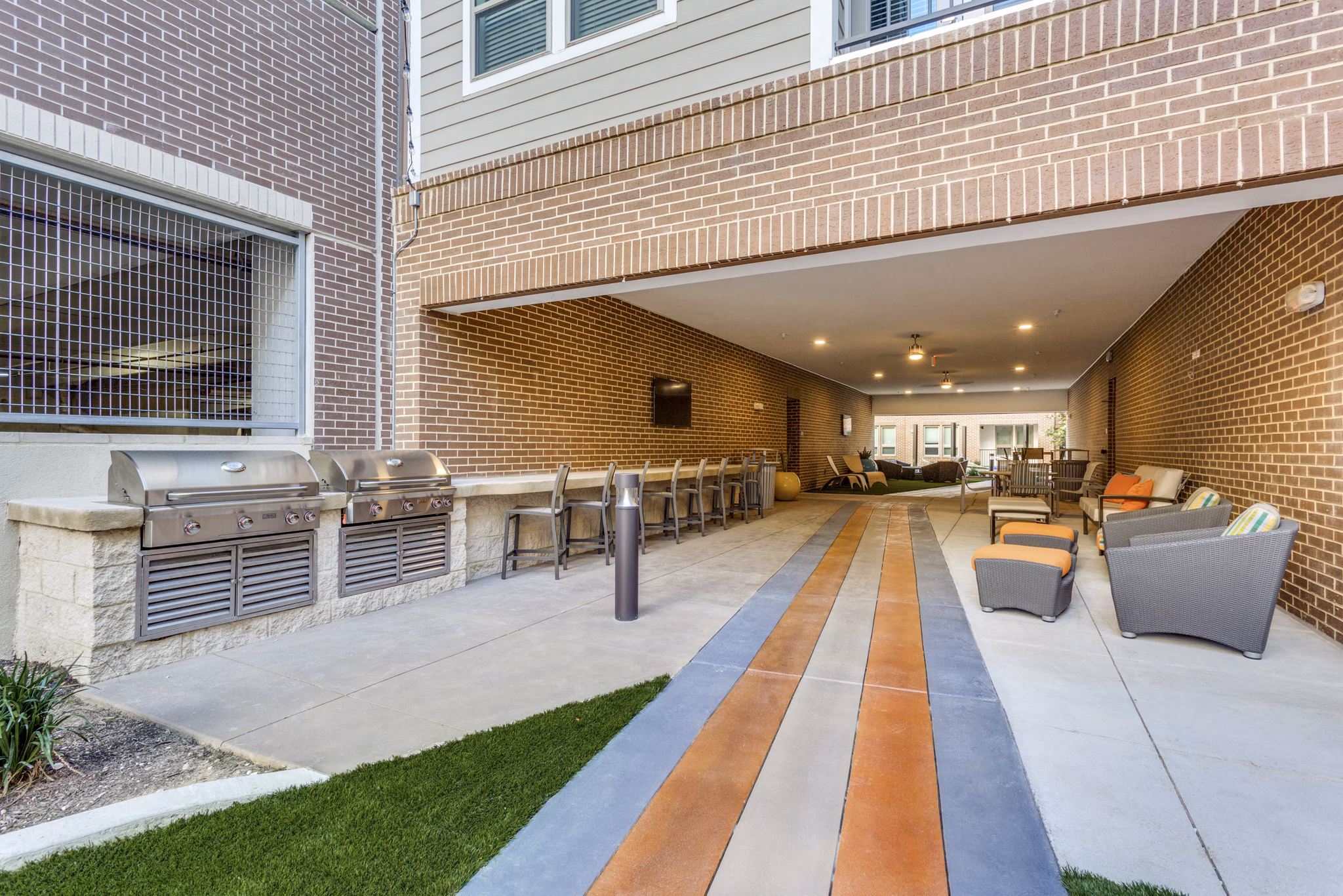 Outdoor grill area with modern seating at Quest Apartments, offering a luxury community cooking experience