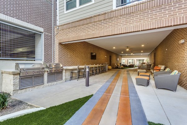 Outdoor grill area with modern seating at Quest Apartments, offering a luxury community cooking experience