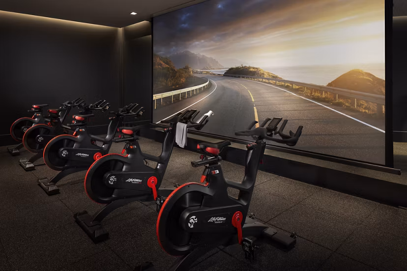 Yoga/spin studio at Diega Apartments with modern equipment and bright interiors for luxury fitness experiences