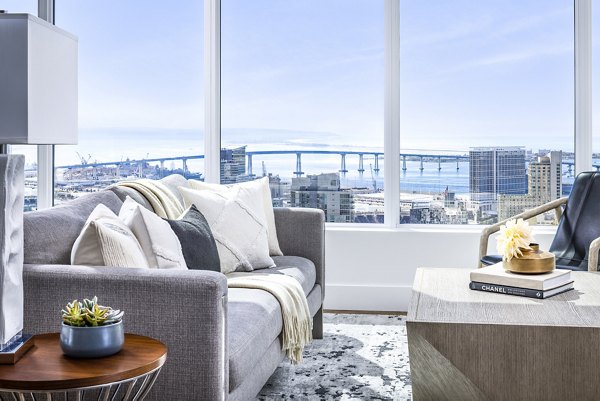 Spacious living room with modern decor in Diega Apartments, featuring luxurious seating and large windows