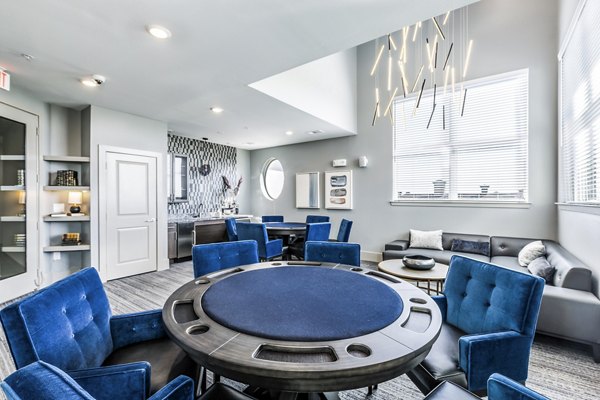 Clubhouse game room featuring billiards and lounge at Arista Riverstone Apartments with modern decor and ample seating