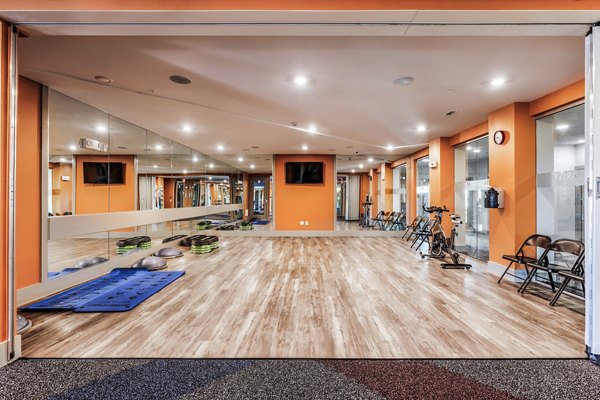 Yoga studio with wood floors and large mirrors at Arista Riverstone Apartments Luxury fitness spaces enhancing wellness-focused lifestyles