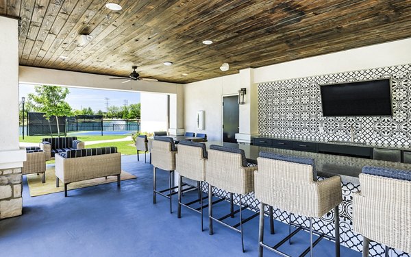 An outdoor patio with elegant seating at Arista Riverstone Apartments, ideal for relaxation and socializing in a tranquil setting