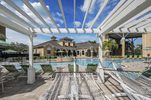 Pool patio featuring lounge chairs and cabanas at The Lofts Apartments, offering luxury outdoor relaxation