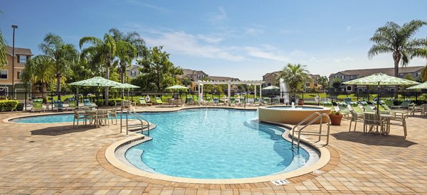 Relaxing poolside oasis with lounge chairs at The Lofts Apartments