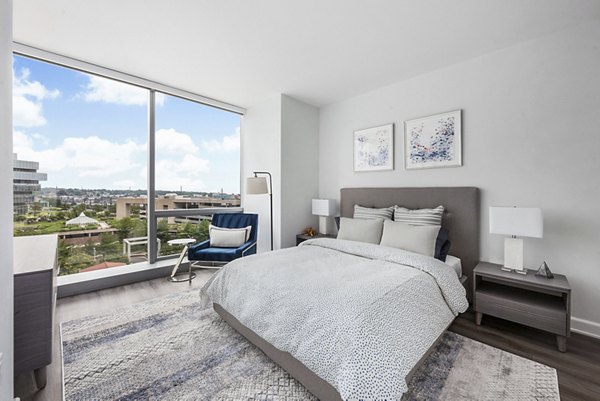 Cozy bedroom with neutral decor and large windows at Atlantic Station West Apartments