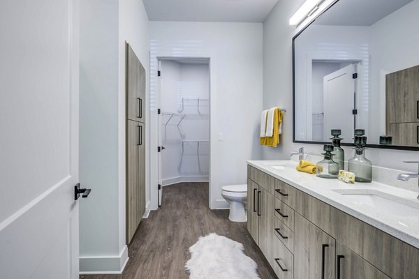 Bathroom featuring sleek fixtures and marble countertops at Candour House Apartments