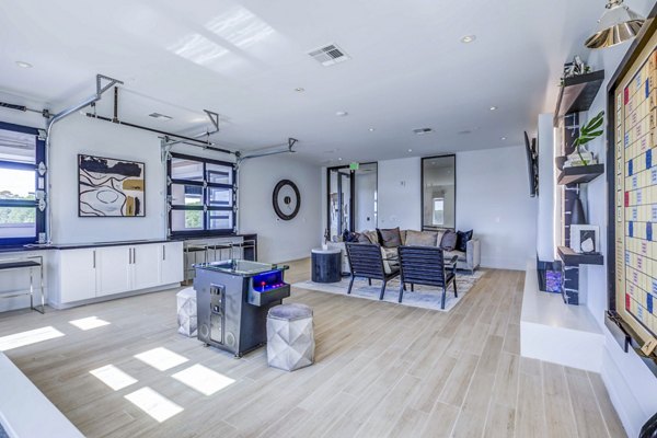 Clubhouse game room with billiards and seating at Candour House Apartments