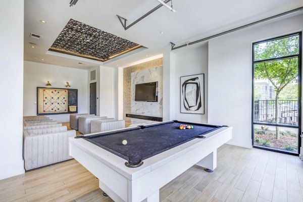 Clubhouse game room with modern dÃ©cor and pool table at Candour House Apartments, a Greystar luxury property