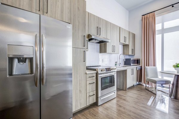 Modern kitchen with stainless steel appliances at Candour House Apartments