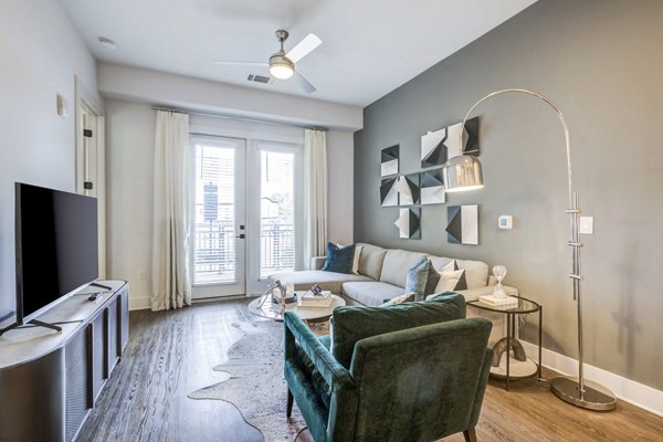 Modern living room with contemporary furniture and large windows at Candour House Apartments