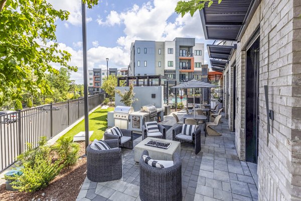 Grill area and patio at Candour House Apartments offering outdoor cooking space