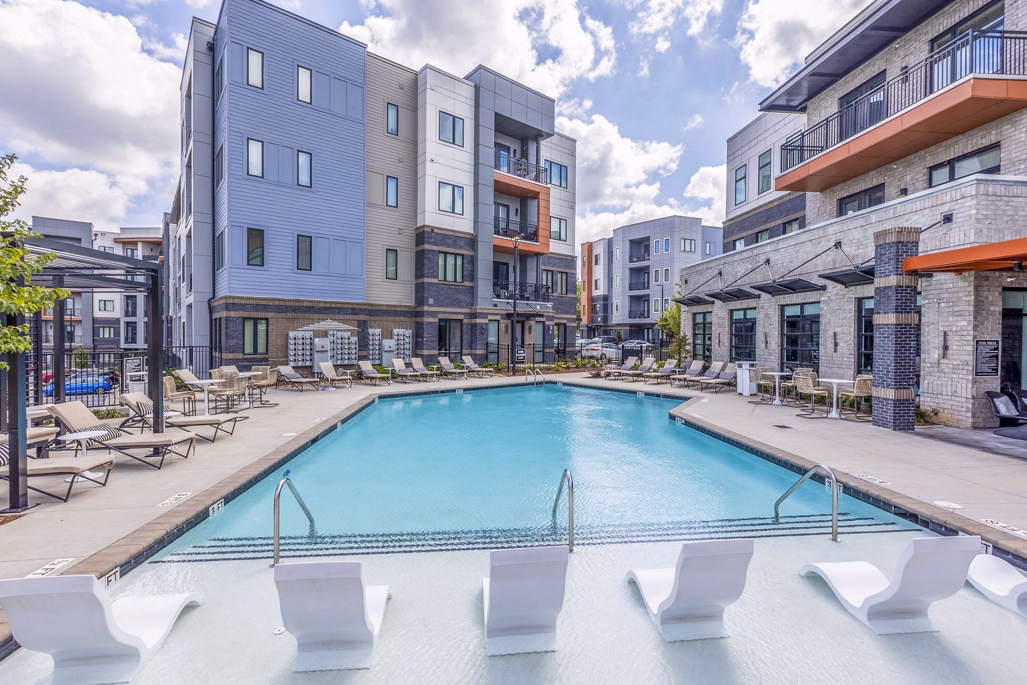 Pool with lounge chairs at Candour House Apartments offering luxury living in a tranquil setting
