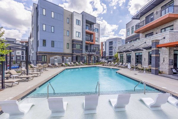 Pool with lounge chairs at Candour House Apartments offering luxury living in a tranquil setting