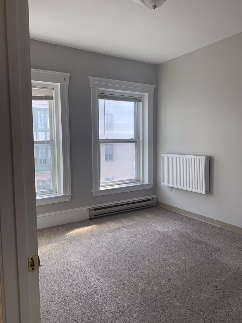 Cozy bedroom with modern decor at Colton Apartments, featuring a comfortable bed and stylish lighting fixtures
