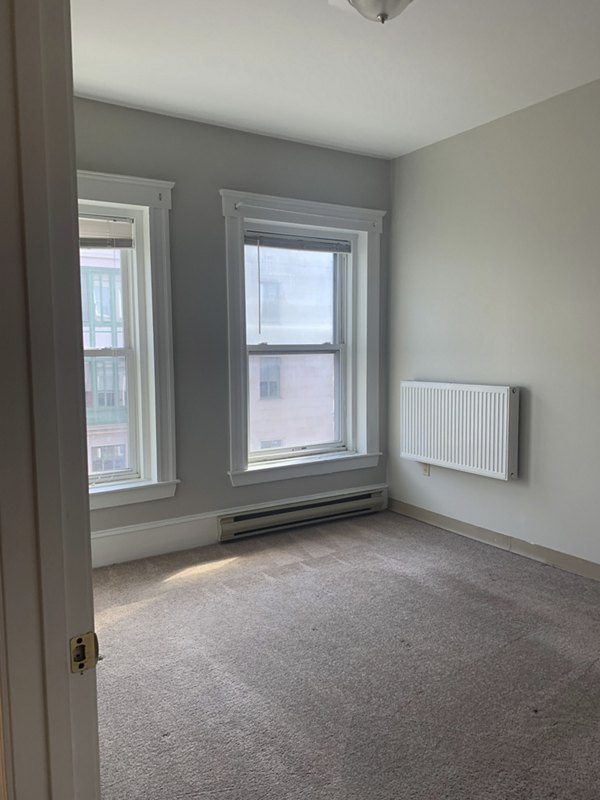 Cozy bedroom with modern decor at Colton Apartments, featuring a comfortable bed and stylish lighting fixtures