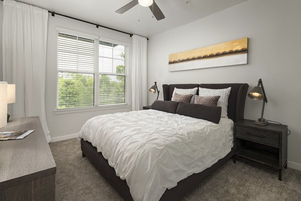 Tapestry at Brentwood Town Center Apartments: Elegant bedroom with modern decor and large windows