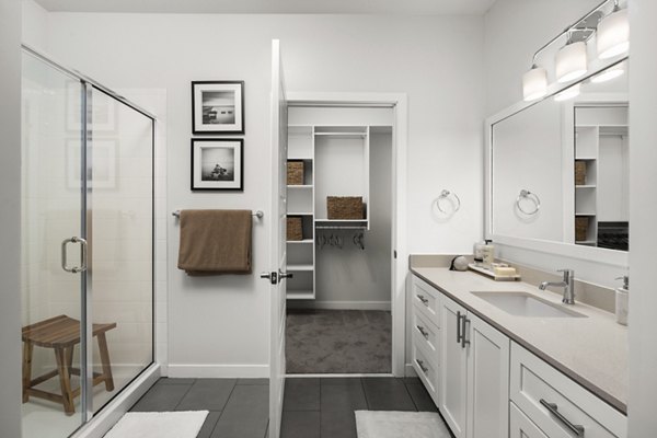 Guest bathroom with elegant fixtures and large vanity mirror in Tapestry at Brentwood Town Center Apartments, perfect for luxury living