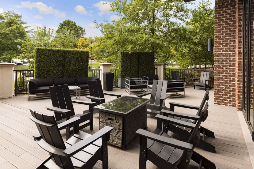 Patio at Tapestry at Brentwood Town Center Apartments featuring stylish outdoor seating and lush landscaping
