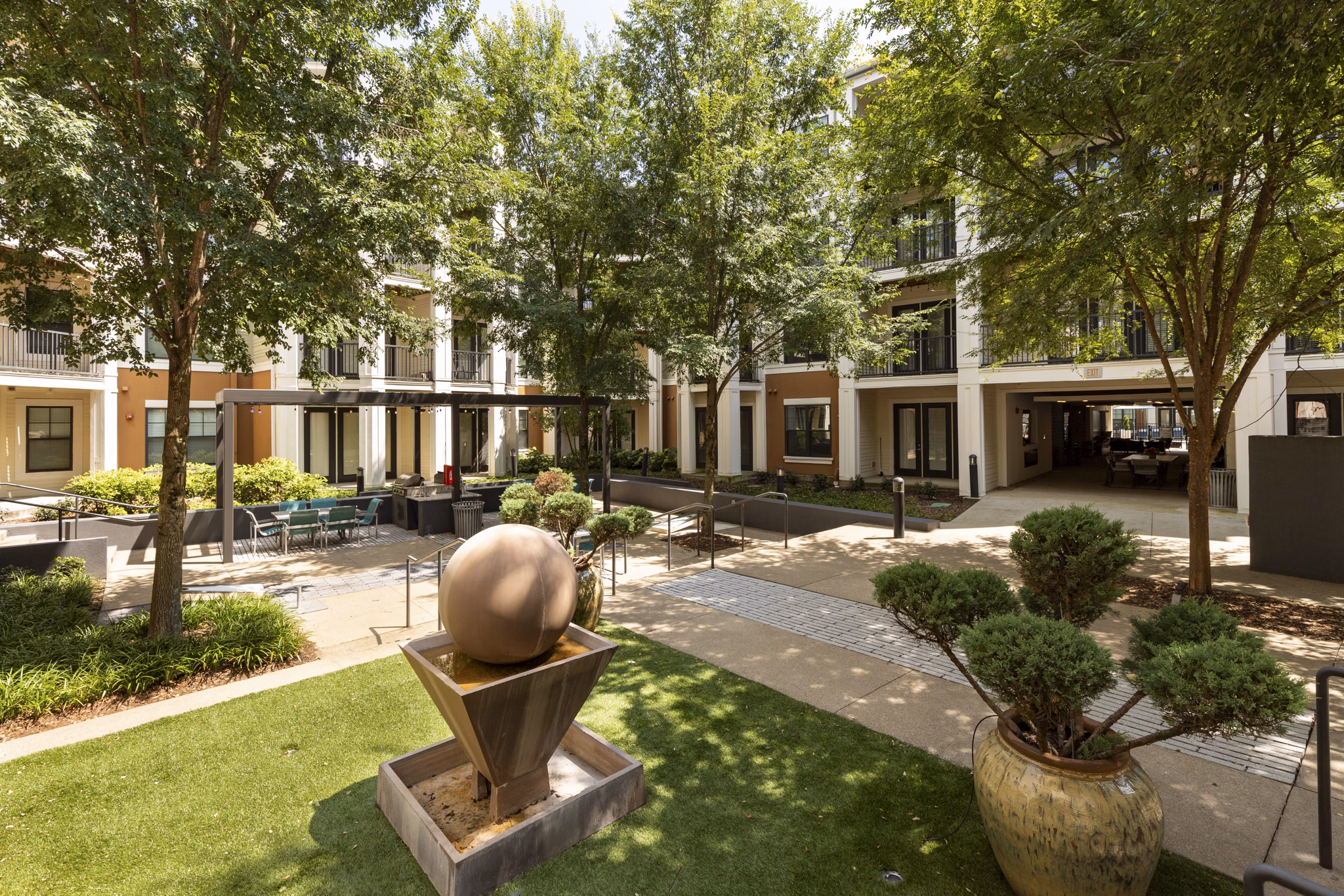 Courtyard featuring lush gardens and comfortable seating at Tapestry at Brentwood Town Center Apartments
