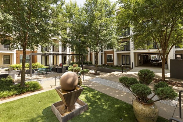 Courtyard featuring lush gardens and comfortable seating at Tapestry at Brentwood Town Center Apartments
