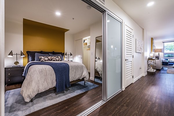 Cozy bedroom with modern furnishings at Elara at the Market Apartments
