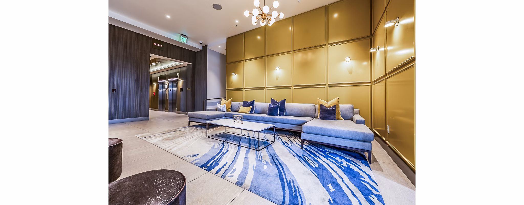Modern clubhouse lobby featuring stylish seating and art at Elara at the Market Apartments