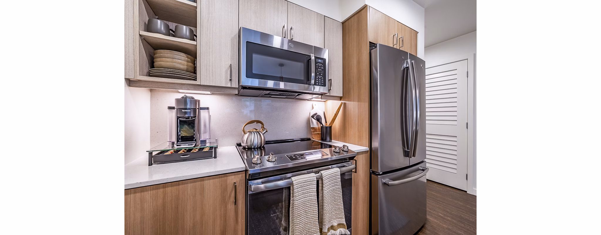 Modern kitchen with stainless steel appliances at Elara at the Market Apartments