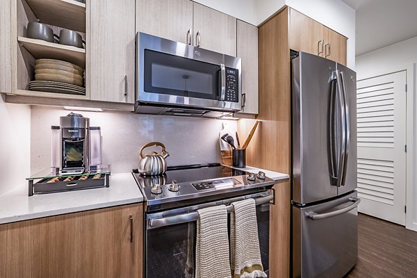 Modern kitchen with stainless steel appliances at Elara at the Market Apartments