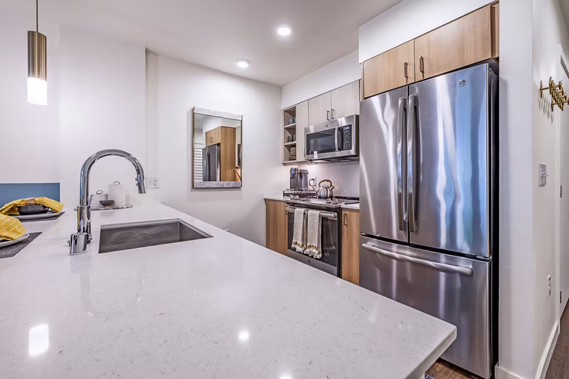 Modern kitchen with stainless steel appliances at Elara at the Market Apartments