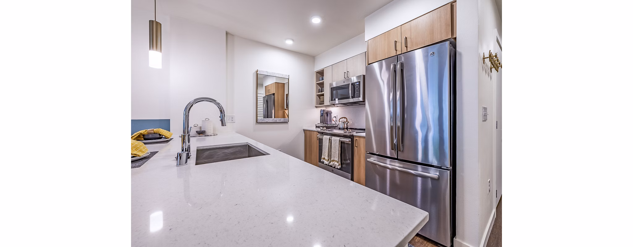 Modern kitchen with stainless steel appliances at Elara at the Market Apartments