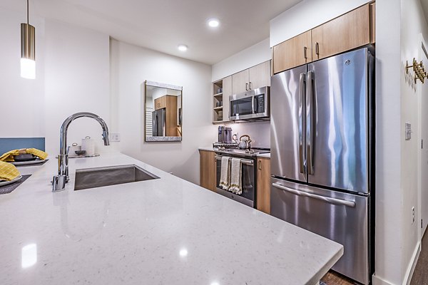 Modern kitchen with stainless steel appliances at Elara at the Market Apartments