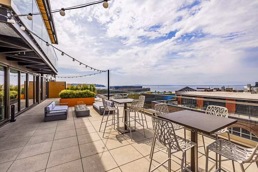 Elara at the Market Apartments: Cozy patio with modern outdoor furniture and city views