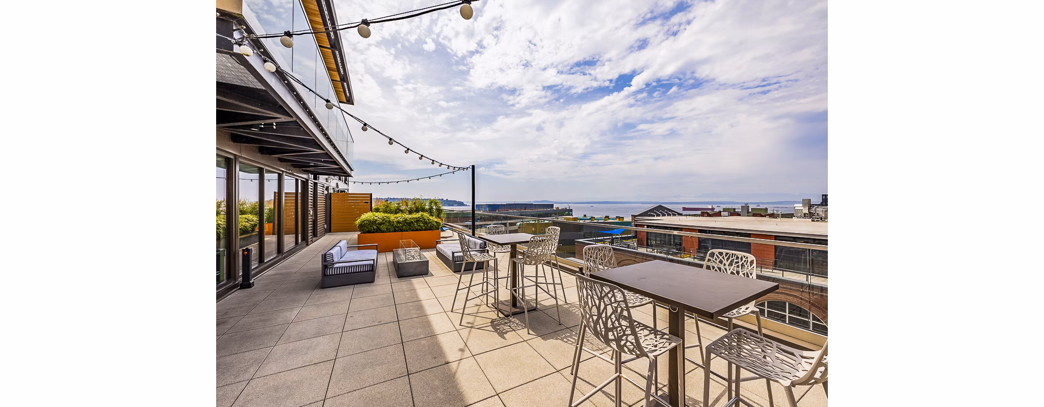 Elara at the Market Apartments: Cozy patio with modern outdoor furniture and city views