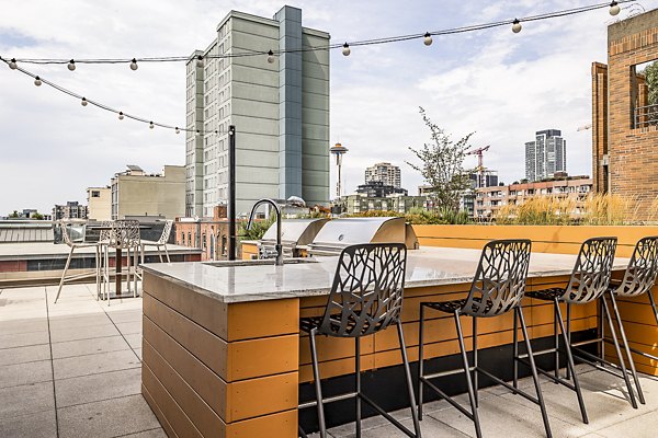 Outdoor patio with grill area at Elara at the Market Apartments featuring comfortable seating for social gatherings